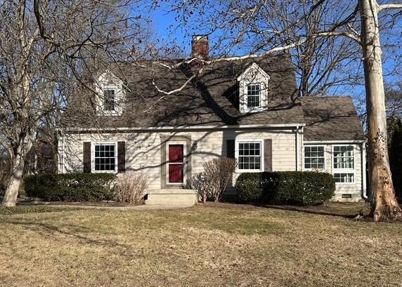 cape cod-style house featuring crawl space, a chimney, and a front yard