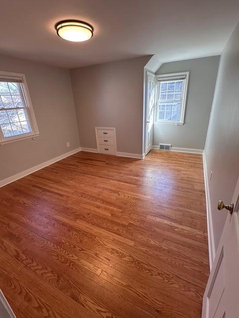 empty room featuring baseboards, visible vents, and light wood-type flooring