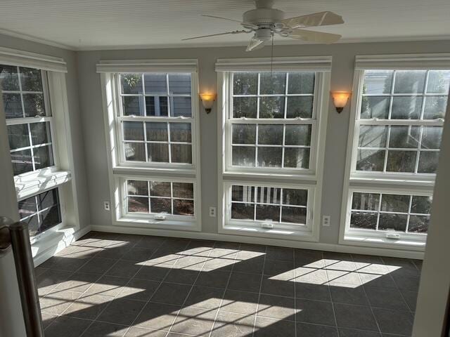 unfurnished sunroom featuring a ceiling fan