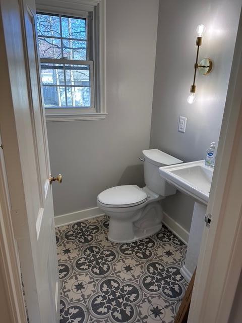 bathroom with tile patterned flooring, toilet, and baseboards