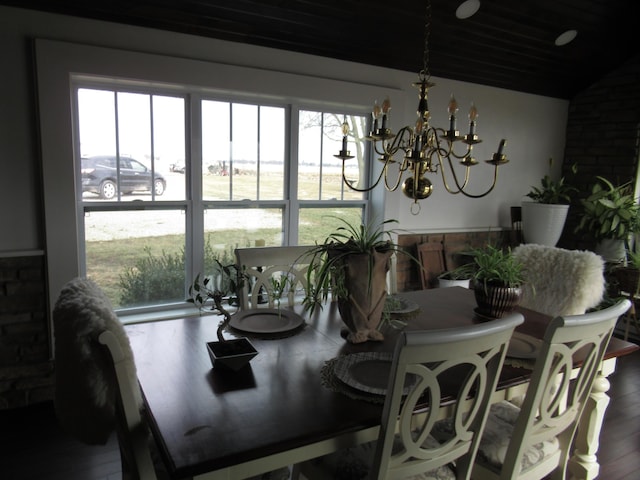 dining area featuring vaulted ceiling, an inviting chandelier, and hardwood / wood-style floors