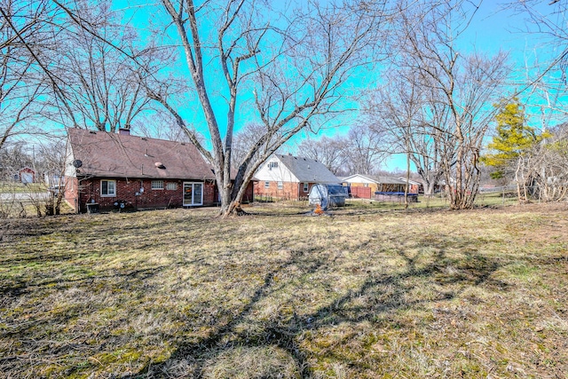 view of yard featuring a trampoline and fence