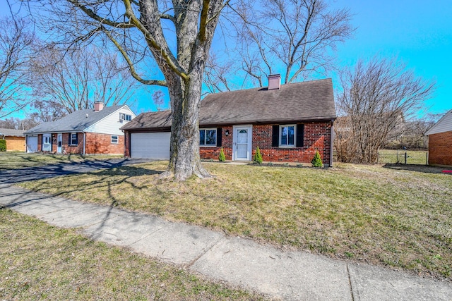 view of front of home with a front lawn, a garage, brick siding, and a chimney