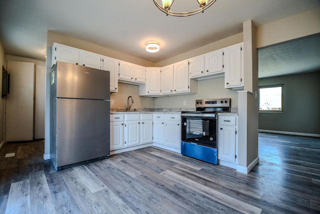 kitchen featuring white cabinets, wood finished floors, appliances with stainless steel finishes, and a sink