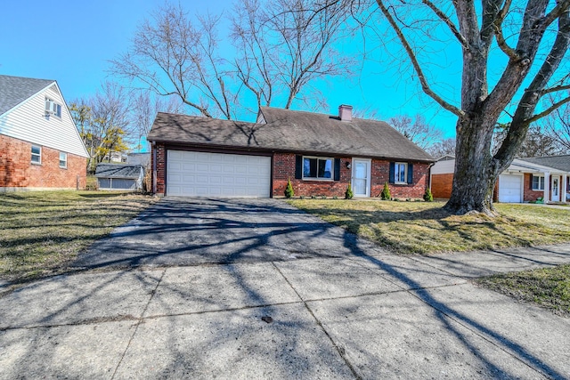 view of front facade with aphalt driveway, an attached garage, a front yard, and brick siding