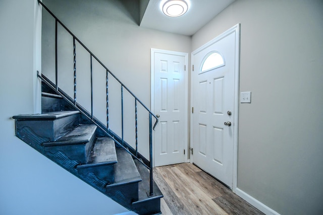 entryway featuring stairway, baseboards, and light wood-type flooring