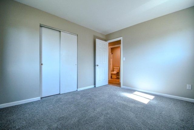 unfurnished bedroom featuring baseboards, carpet floors, and a closet