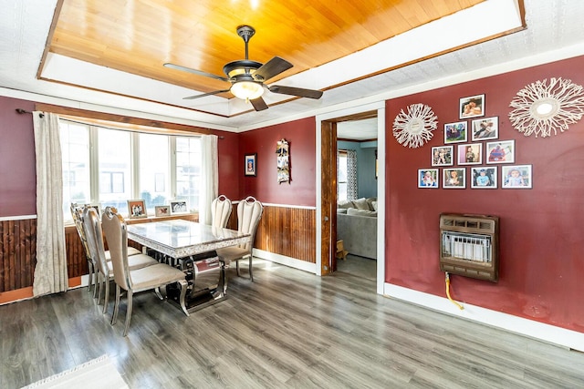 dining room featuring a tray ceiling, wood finished floors, heating unit, and wood ceiling