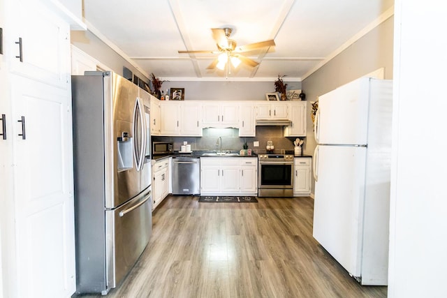 kitchen with decorative backsplash, dark countertops, a ceiling fan, appliances with stainless steel finishes, and a sink
