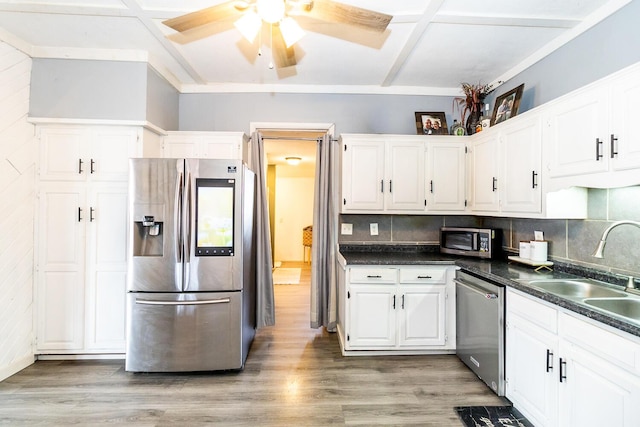 kitchen featuring white cabinetry, a sink, stainless steel appliances, and light wood-style floors