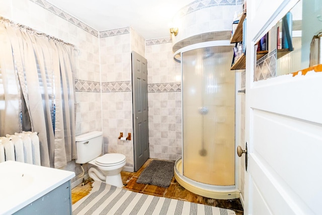 full bathroom featuring tile walls, vanity, a shower stall, and radiator