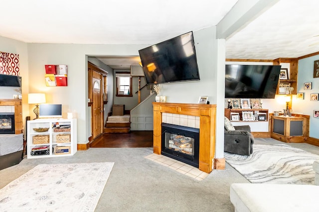living area with carpet floors, baseboards, a fireplace, and stairs
