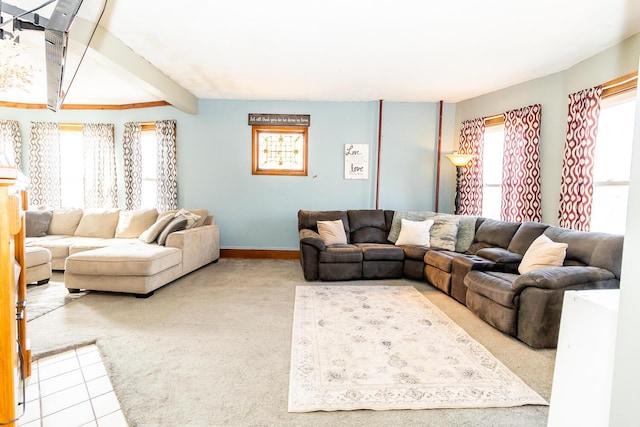 living area featuring baseboards, beamed ceiling, and carpet