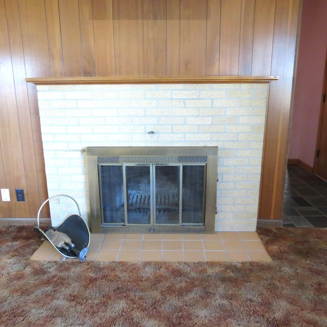 interior details featuring carpet floors, wood walls, and a fireplace