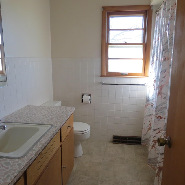 full bathroom with tile patterned flooring, tile walls, toilet, and vanity