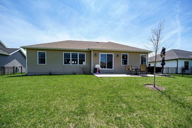 rear view of house with fence, a yard, and a patio