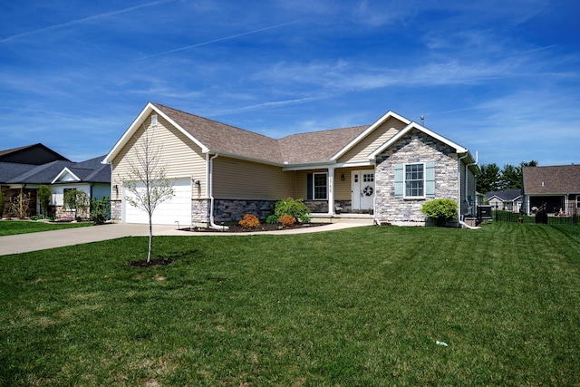 view of front of house featuring a front lawn, stone siding, concrete driveway, an attached garage, and a shingled roof