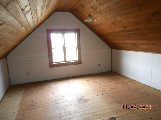 additional living space with wood ceiling, lofted ceiling, and hardwood / wood-style flooring