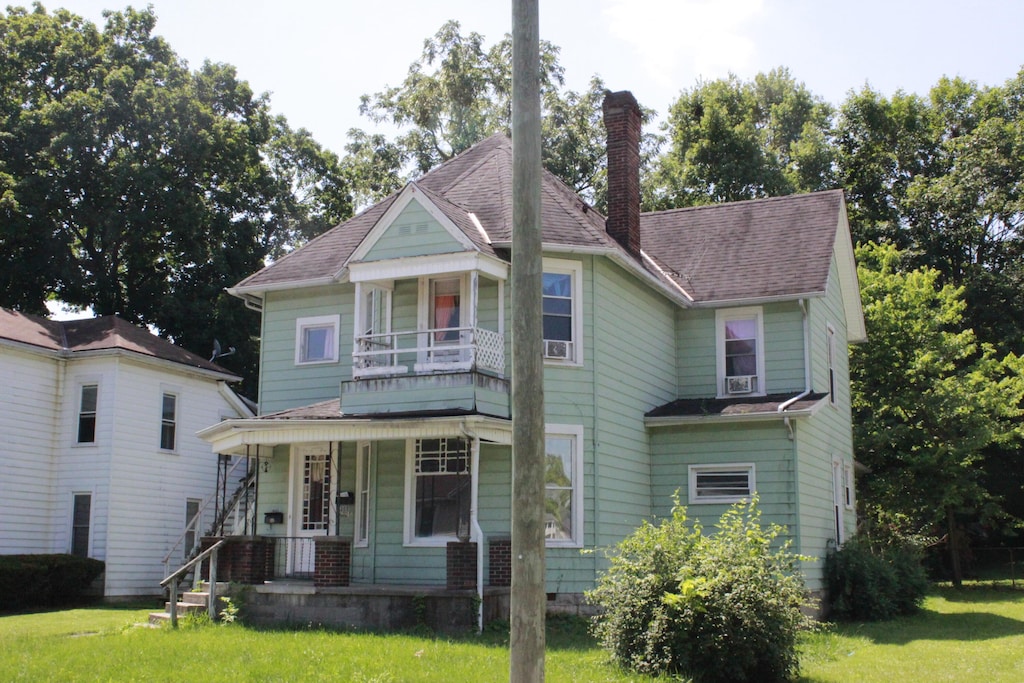1205 W High St, Springfield, OH 45506 - victorian house with a porch, a balcony, a chimney, and a front yard