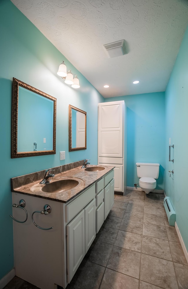 bathroom featuring baseboard heating, vanity, toilet, and a textured ceiling