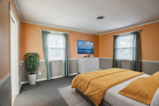 bedroom with crown molding, multiple windows, and carpet