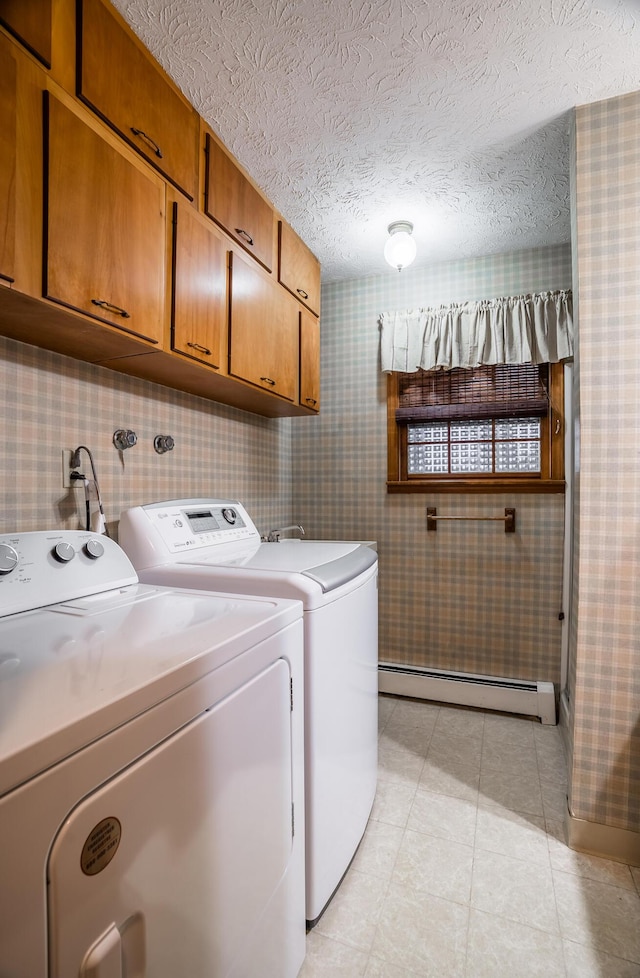 washroom featuring a baseboard radiator, separate washer and dryer, cabinets, light tile patterned floors, and a textured ceiling