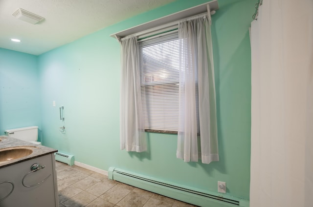 bathroom featuring a baseboard radiator, vanity, and toilet