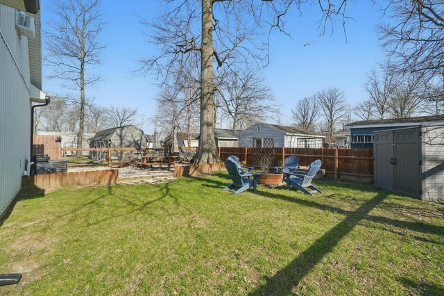 9436 Cottonwood Dr, Huntsville, OH 43324 - view of yard featuring fence, a storage shed, an outdoor fire pit, and an outdoor structure