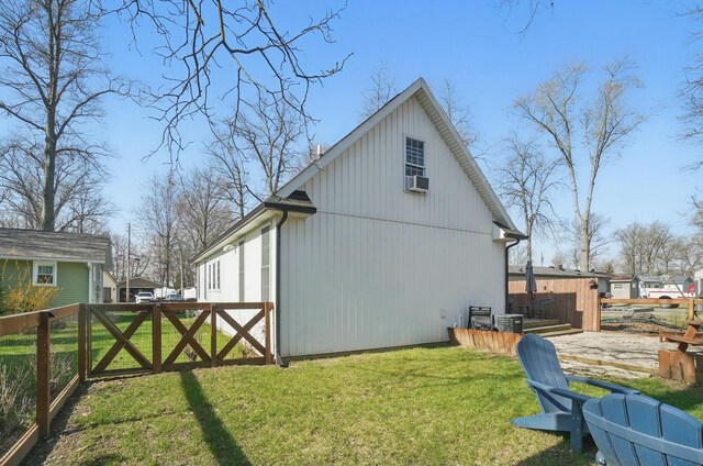 9436 Cottonwood Dr, Huntsville, OH 43324 - view of side of property featuring cooling unit, a gate, a lawn, fence, and central AC