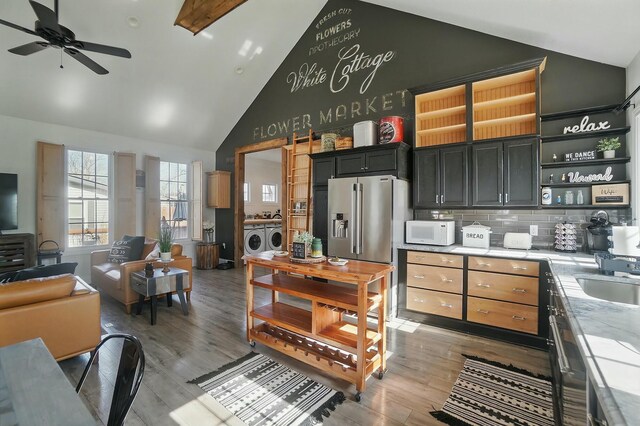9436 Cottonwood Dr, Huntsville, OH 43324 - kitchen with washing machine and clothes dryer, high vaulted ceiling, white microwave, light countertops, and open floor plan
