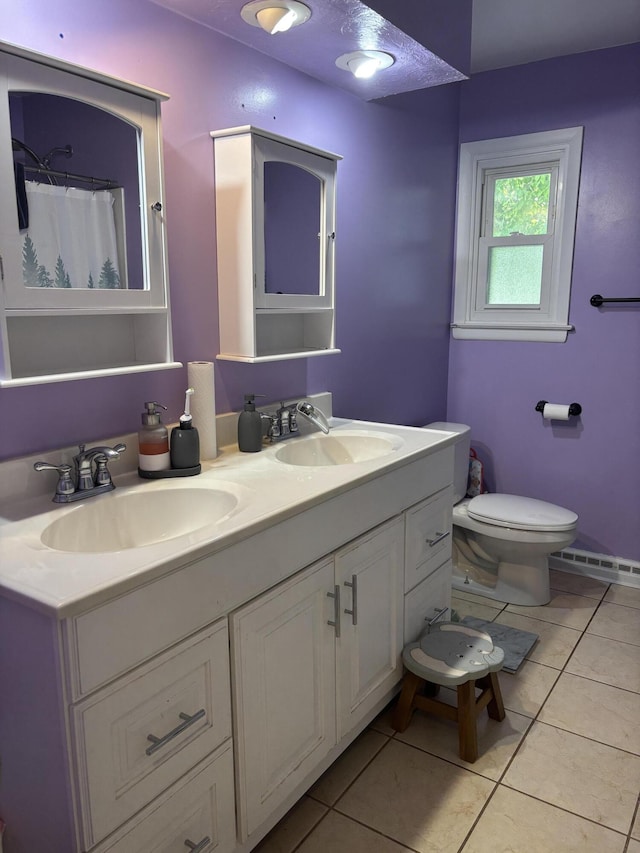 825 Dorothy Ln, Saint Marys, OH 45885 - bathroom with double vanity, toilet, tile patterned floors, and baseboard heating