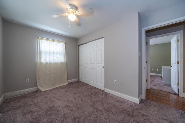 unfurnished bedroom featuring a ceiling fan, dark colored carpet, a closet, and baseboards