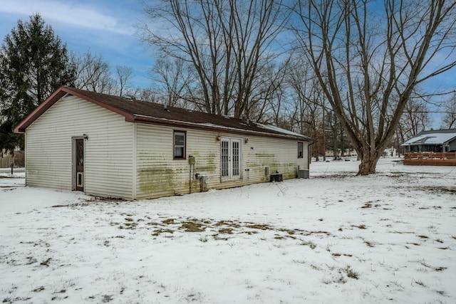 snow covered back of property with cooling unit