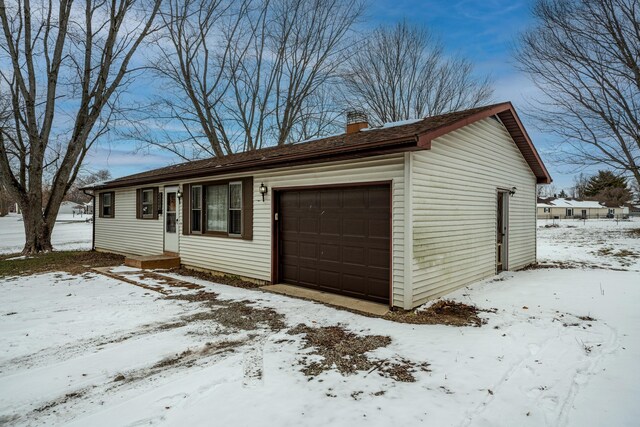 view of front of house featuring a garage and a chimney