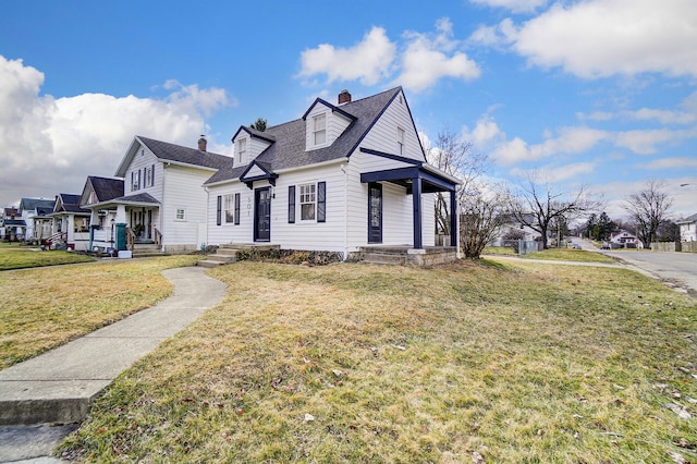 view of front of home with a residential view, a chimney, a front yard, and a shingled roof