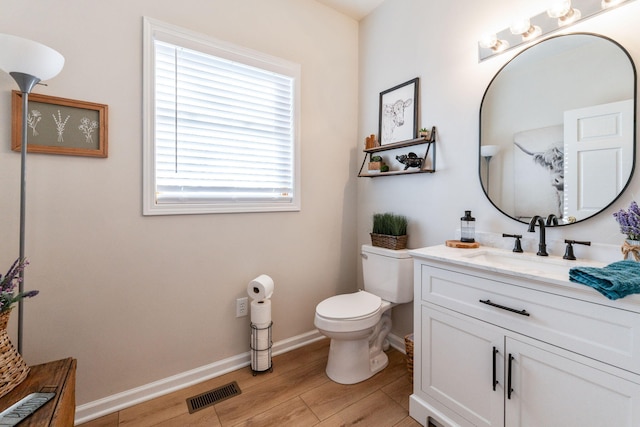 bathroom with hardwood / wood-style flooring, vanity, and toilet