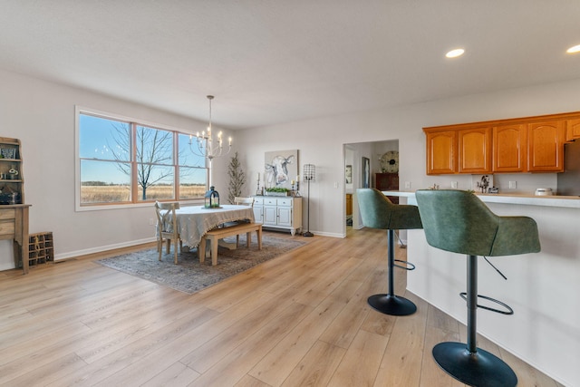 dining area featuring an inviting chandelier and light hardwood / wood-style floors