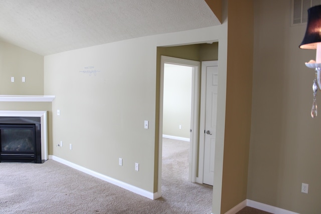 unfurnished living room with carpet, a glass covered fireplace, and baseboards