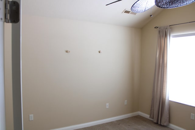 unfurnished room with light carpet, visible vents, baseboards, lofted ceiling, and ceiling fan