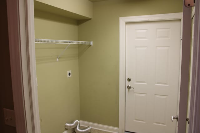 laundry area with laundry area, hookup for an electric dryer, and baseboards