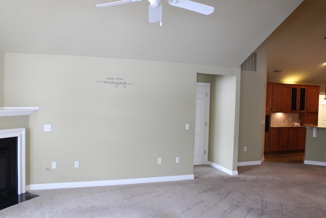 unfurnished living room featuring visible vents, a fireplace with flush hearth, light carpet, vaulted ceiling, and baseboards