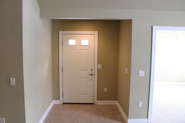 entryway featuring light tile patterned flooring and baseboards