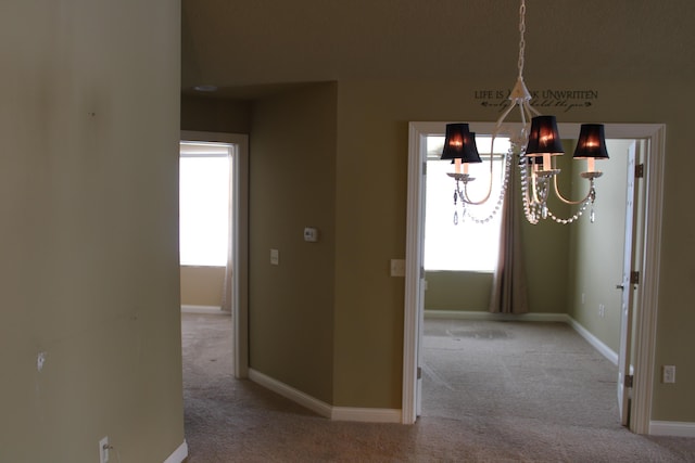 unfurnished dining area with carpet floors, plenty of natural light, and baseboards