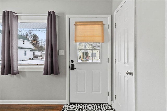 doorway featuring wood finished floors and baseboards