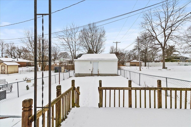 yard layered in snow featuring an outdoor structure and fence private yard
