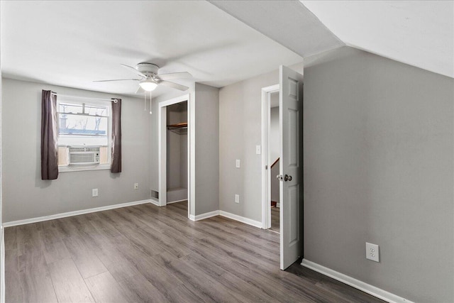 unfurnished bedroom featuring dark wood finished floors, a closet, baseboards, cooling unit, and ceiling fan