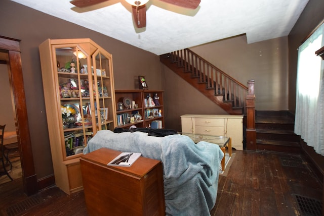 interior space featuring ceiling fan, stairway, wood-type flooring, and visible vents