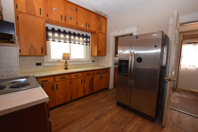 kitchen with a wealth of natural light, dark wood finished floors, light countertops, and stainless steel fridge with ice dispenser