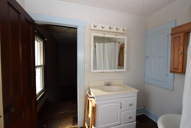 full bath featuring toilet, vanity, wood finished floors, a shower with curtain, and baseboards