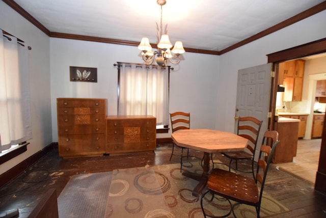 dining space with baseboards, ornamental molding, a notable chandelier, and wood finished floors